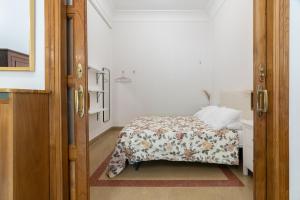1 dormitorio con 1 cama con colcha de flores en Casa Bogart, en Ourense