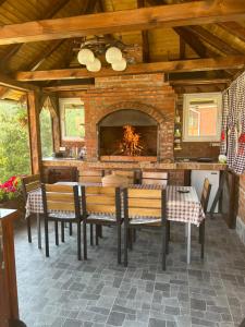 a dining room with a fireplace and a table and chairs at Vila Zorica Vodice in Zlatibor