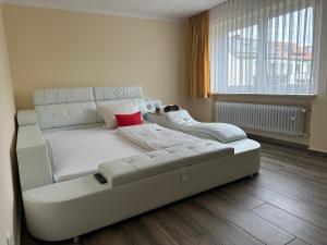 a white couch in a room with a large window at Pension Hubertus in Bad Steben