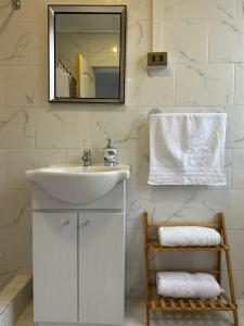 a white bathroom with a sink and a mirror at Casa Di Patti in Santiago