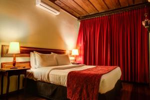 een hotelkamer met een bed en rode gordijnen bij Hotel Pousada do Arcanjo in Ouro Preto