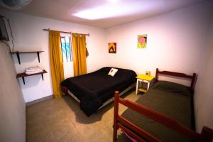 niewielka sypialnia z 2 łóżkami i oknem w obiekcie Huaka Hostal w mieście Cafayate