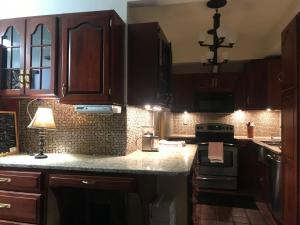 a kitchen with wooden cabinets and a counter top at Little Castle in Villanova