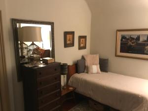 a bedroom with a bed and a dresser and a mirror at Little Castle in Villanova