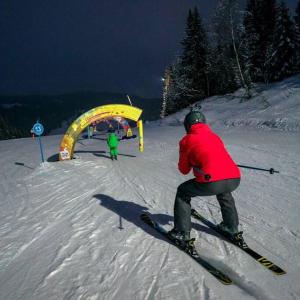 a person in a red jacket on skis in the snow at Appartement Manigod/La clusaz in Manigod