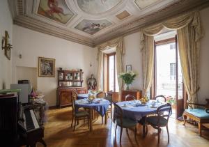 una sala da pranzo con tavoli, sedie e soffitto di Affreschi Su Roma Luxury B&B a Roma