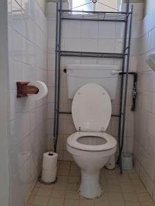 a bathroom with a toilet with two racks on it at KASP Cottage in Underberg