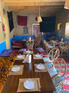 uma sala de jantar com mesa e cadeiras e um quarto em Auberge Agoudal em Agoudal