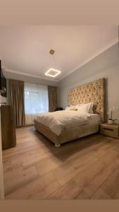 1 dormitorio con 1 cama grande y suelo de madera en Casa Di David en Buzău