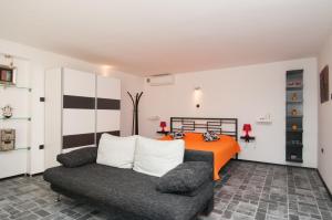 a bedroom with an orange bed and a couch at Apartment Gala Opatija in Opatija
