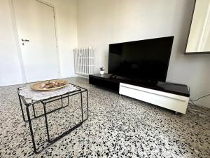 sala de estar con TV de pantalla plana y mesa en Luce Apartament, en Cassina deʼ Pecchi