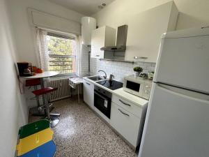 cocina blanca con fregadero y nevera en Luce Apartament en Cassina deʼ Pecchi