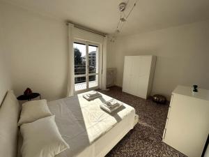 1 dormitorio con cama blanca y ventana en Luce Apartament, en Cassina deʼ Pecchi