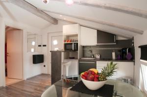 a kitchen with a glass table and a bowl of fruit at Apartment Gala Opatija in Opatija