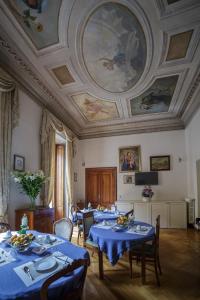 a dining room with tables with blue tablecloths at Affreschi Su Roma Luxury B&B in Rome