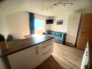 uma cozinha e sala de estar com um sofá azul em Ferienwohnung Wipptalblick em Navis