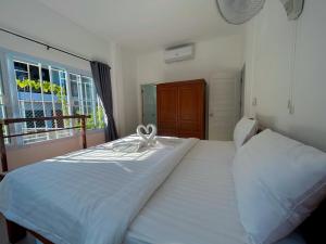 una camera da letto con un grande letto bianco e una finestra di SuanMalisamuiVilla G02 a Ko Samui