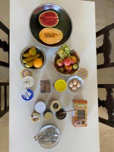 レティムノ・タウンにあるEftihia Apartments by the seaの白いテーブル(果物、その他の食材を入れた器)