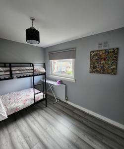 a bedroom with two bunk beds and a window at Stunning 3 bedroom FMHomes & Apartments in Uddingston