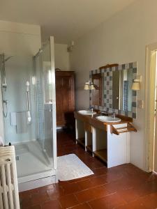 a bathroom with two sinks and a shower at Chateau de Montcuquet in Lautrec