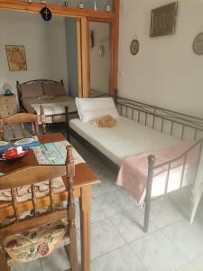 a room with two beds and a table and a table at Spitaki mou in Kamena Vourla
