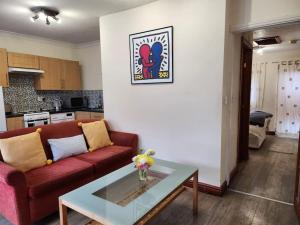 a living room with a red couch and a glass table at * Cotswolds Get-Away Annex * in Cleeve Prior