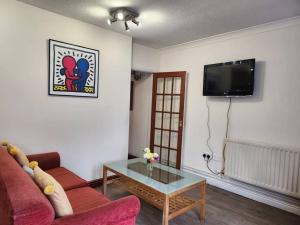 a living room with a red couch and a table at * Cotswolds Get-Away Annex * in Cleeve Prior