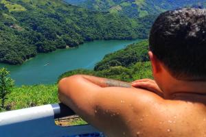 a man looking out over a lake from a mountain at Casa Kakawa Ecolodge in Samaná