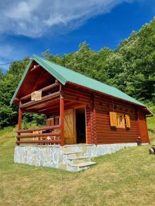 Mountain House Komovi في Andrijevica: كابينة خشب ذات سقف أخضر