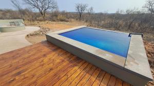 a swimming pool on top of a wooden deck at ZuriCamp - Tent Zahir in Tsumeb