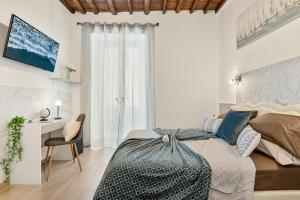 a white bedroom with a bed and a desk at Alby Express Rooms in La Spezia