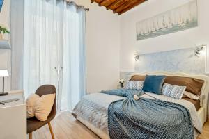 a white bedroom with a bed and a chair at Alby Express Rooms in La Spezia