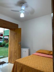 1 dormitorio con 1 cama y ventilador de techo en Pousada Luz da Vila Itaúnas en Itaúnas