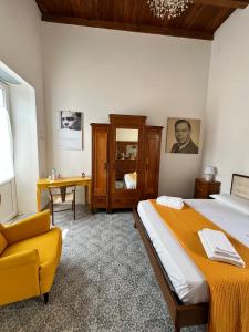 sypialnia z dużym łóżkiem i żółtym krzesłem w obiekcie Residenza La Meridiana w mieście Briatico