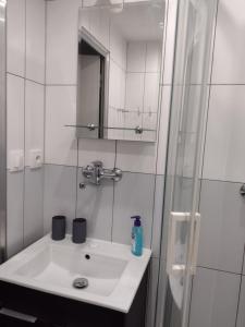 a white bathroom with a sink and a shower at Apartmán Uvalská in Karlovy Vary