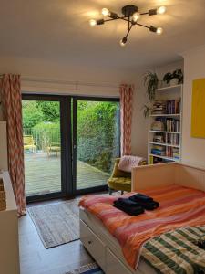 een slaapkamer met een bed en een glazen schuifdeur bij Private room with terrace and free parking in Edinburgh