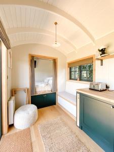 a room with a kitchen with a counter and a window at The Rabbit Warren Shepherd Hut in Ketton