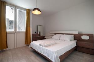 um quarto com uma cama grande e lençóis brancos em Mitovski Apartment em Skopje