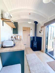 a kitchen with a sink and a stove at The Rabbit Warren Shepherd Hut in Ketton