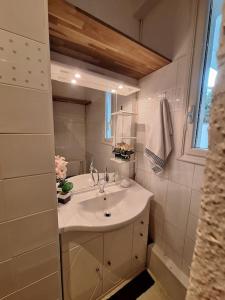 Un baño blanco con lavabo y espejo. en Self Contained City Apartment, en Perpiñán
