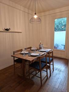 mesa de comedor con 4 sillas y luz en Self Contained City Apartment, en Perpiñán