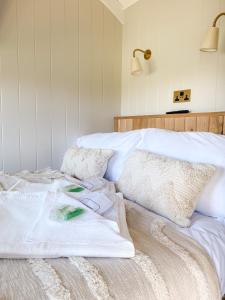 a bedroom with a bed with white sheets and pillows at The Rabbit Warren Shepherd Hut in Ketton