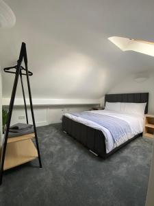 um quarto com uma cama grande com uma moldura preta em Wards House Loft Apartment, Matlock em Matlock