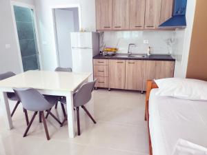 a kitchen with a white table and chairs and a bed at Twins Apartment in Përmet