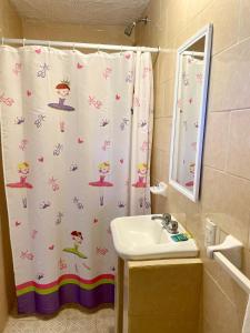 a bathroom with a shower curtain and a sink at Hotel Bigu in Puerto Escondido