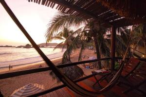 a hammock on a beach with a view of the ocean at Cabañas Punta Placer in San Agustinillo
