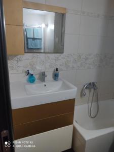 ein Badezimmer mit einem Waschbecken, einem Spiegel und einer Badewanne in der Unterkunft All saints in Athen