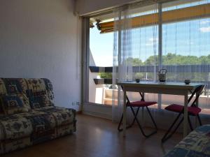 ein Wohnzimmer mit einem Tisch, einem Sofa und einem Fenster in der Unterkunft Appartement Port Camargue, 1 pièce, 4 personnes - FR-1-250-157 in Le Grau-du-Roi
