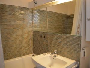 ein Badezimmer mit einem Waschbecken, einer Badewanne und einem Spiegel in der Unterkunft Appartement Port Camargue, 1 pièce, 4 personnes - FR-1-250-157 in Le Grau-du-Roi