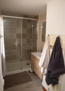 een badkamer met een douche en een wastafel bij L'Aube Normande 